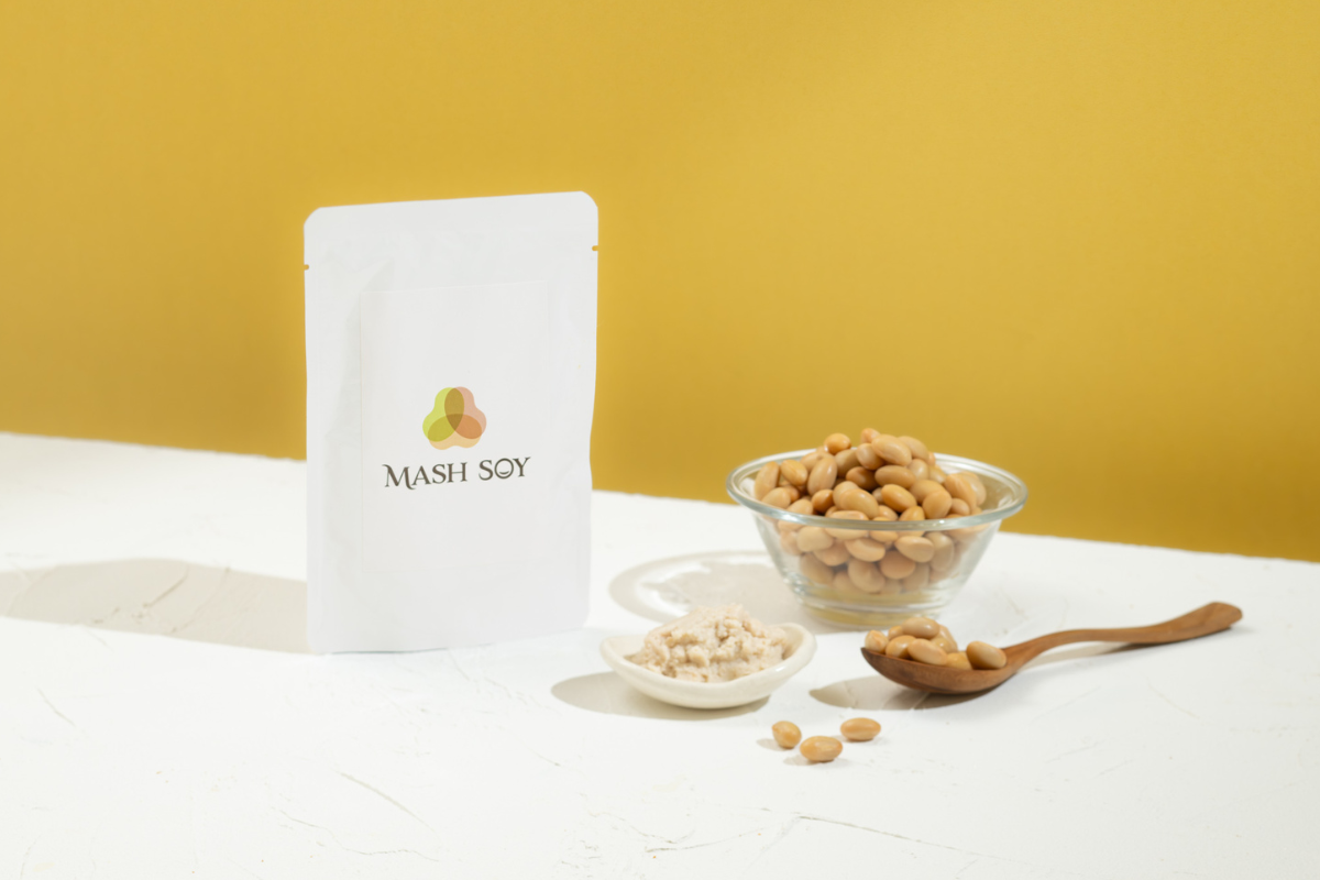 自社製品「MASH SOY」のパッケージ、原料の大豆、ペースト。栄養満点の大豆ペーストを使った極上レシピ集記事のアイキャッチ画像。